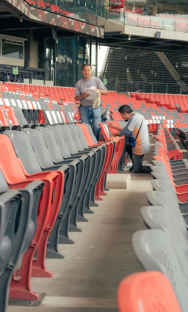 A man is working on a stadium with empty seats scaled